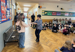 Pani pedagog i nauczyciel wspierający ucznia odbiera karteczkę z życzeniami.