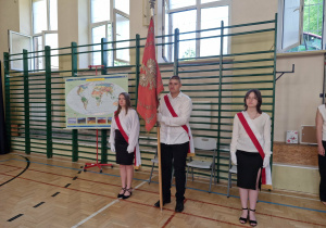 Sala gimnatyczna,wprowadzenie sztandaru szkoły. Trzech ucznów z klasy ósmej