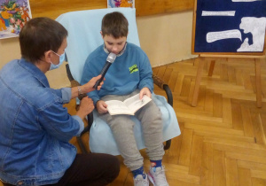 Uczeń klasy V czyta fragment książki pt. ,,Kubuś Puchatek".