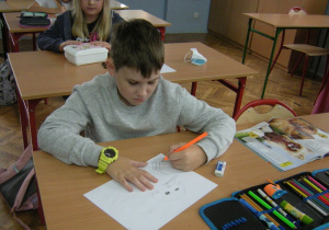 Uczeń rysuje plakat podczas dnia muzyki