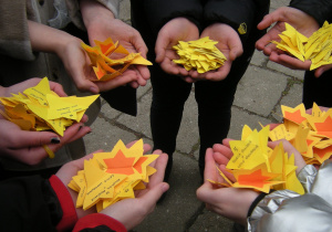 Uczniowie trzymają w rękach żółte żonkile