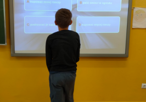Uczeń rozwiązuje zadanie przy tablicy interaktywnej
