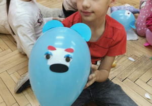 Uczeń prezentuje misiowy balon
