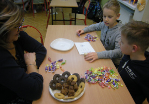 Uczniowie podczas gry w drejdla na cukierki