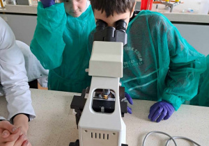 Uczeń obserwujący próbki pod mikroskopem
