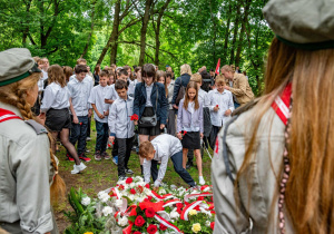 Uczniowie naszej szkoły kładą pod pomnikiem kwiaty.
