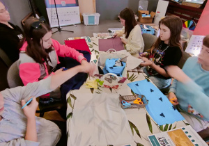 Uczennice klasy VI poznają historię tkanin. Zainteresowane i zaangażowane.