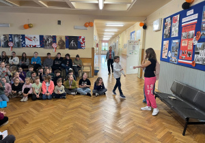 Uczeń z klasy trzeciej odbiera kartkę z życzeniami.