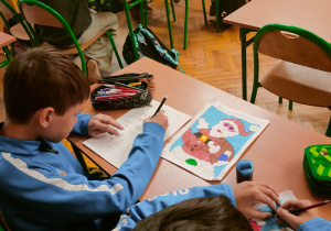 Uczniowie rozwiązujący matematyczne karty pracy