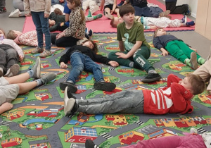 Uczniowie znajdują się na kolorowych matach.Atmosfera jest spokojna i edukacyjna, całe zajęcia mają formę nauki poprzez zabawę, dostosowanej do wieku dzieci.