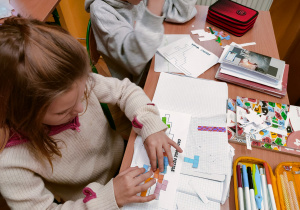 Skupieniu uczniowie klasy IV rozwiązują zagadkę logiczną