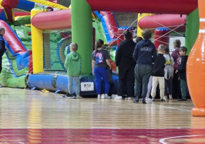 Dzieci na hali sportowej MOSiR oczekują na wejście na wybranego dmuchańca.