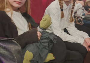 Uczennice klasy czwartek pozują do zdjęcia elegancko ubrane w sali teatralnej