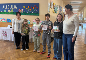 Na zdjęciu organizatorki konkursu ,,Wiosna w moich oczach" pozuje wraz z wyróżnionymi uczniami klas 4-8. Uczniowie mają dyplomy oraz nagrody.