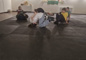 Teatr Arlekin - sala ćwiczeń - przytłumione światło. Uczniowie ustawiali się w różnych pozach. Klęczeli i głowę mieli przy podłodze, bądź leżeli z nogami do góry oraz przytrzymywali rękoma ciężar ciała.