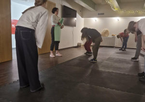 Teatr Arlekin - sala ćwiczeń - przytłumione światło. Uczniowie pochyleni, jakby kłaniali się przed Panią instruktorką