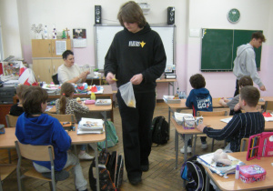 Uczniowie klasy VII rozdają w klasie trzeciej papierowe żonkile