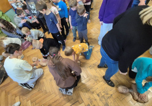 Uczniowie szkoły zgromadzeni na korytarzu, dzieci czekają na wykonanie RKO.